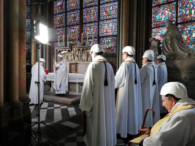 Padres com capacete na primeira missa na Notre-Dame depois do incêndio